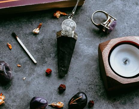 Crystals and candles on a grey marble surface