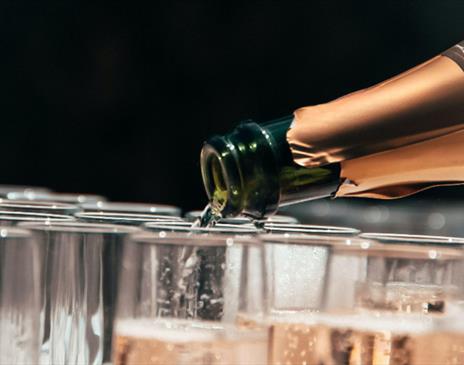 Champagne bottle pouring into glasses