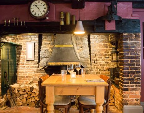 Table in front of a large roaring fireplace.