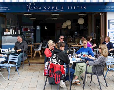 Tables outside the cafe of visitors enjoying the food and views.