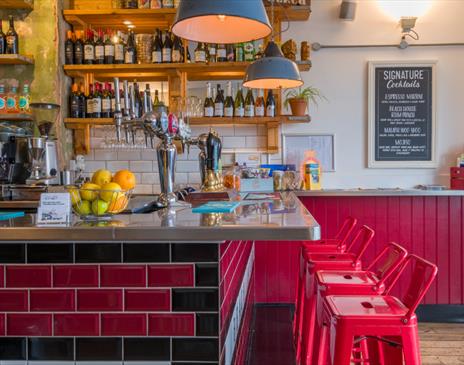 View of the bar with red stools against the bar.