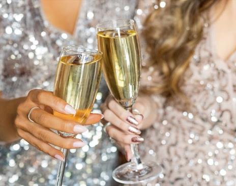 Celebrating the festive season at The Mercure Brighton Seafront, two glasses of Champagne in a cheers.