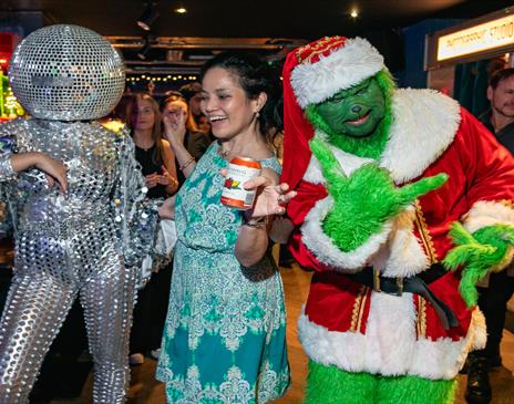 Party goers at Lucky Voice in Brighton dressed up in fancy dress outfits including the Grinch and a dancer wearing disco ball headwear.