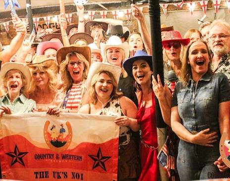 Partygoers enjoying the Country & Western event which will be held at Brighton Racecourse in February.