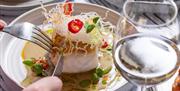 A succulent piece of fish with a glass of white wine.