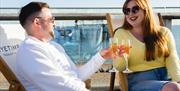 Couple drinking Nyetimber on West Beach Cafe Bar terrace