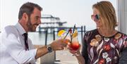 People enjoying cocktails on West Beach terrace