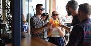 A group enjoying drinks with a cheers, at  Shelter Hall, Brighton