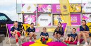 Children sat in front of the Rugby World Cup branding by the Brighton i360