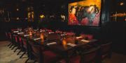 Intimate seating area with a picture of a bull above a table surrounded by chairs.