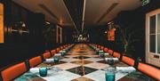 Long table with orange leather chairs surrounding it.