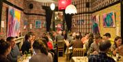 A lively event at the Hotel Pelirocco, groups of people sitting in the bar area chatting and dining.