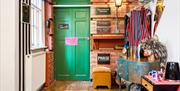 The bright green door of the Rebel Rebel room at Hotel Pelirocco. Bowie inspired wigs sit on the side table.