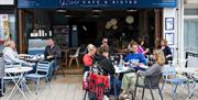 Tables outside the cafe of visitors enjoying the food and views.