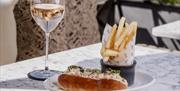 A lobster roll, chips and wine.