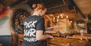 A member of staff setting up a table for customers.