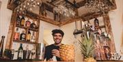 A friendly member of staff behind the bar with a pineapple on it.