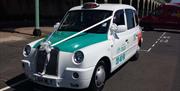 Brighton & Hove Radio Cabs vehicle parked on Madeira Drive decorated for collecting a wedding party.