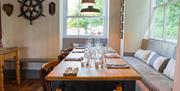 A table by a window with a comfortable bench seat.