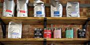 A range of teas and coffees sitting on a shelf in the cafe.