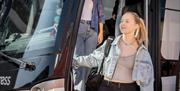 Happy passenger getting off a National Express bus.