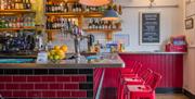 View of the bar with red stools against the bar.