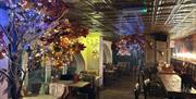 Inside Brighton Music Hall. Image shows a cosy, winter themed bar area with fairy lights and wooden seating.