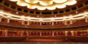 Image courtesy of Hugh Fox. The inside of Brighton Dome's main theatre showing the ceiling lit up emphasising the beautiful architecture and main Dome