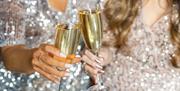 Celebrating the festive season at The Mercure Brighton Seafront, two glasses of Champagne in a cheers.