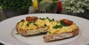 Scrambled egg on sourdough toast with tomatoes on top