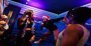 Party goers at Lucky Voice in Brighton dancing and singing in a booth.