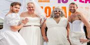 Image courtesy of Jim Carey, Image shows attendees wearing wedding dresses and smiling at the camera.