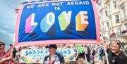 Image courtesy of Jim Carey. Pride goers carrying a sign which reads "we are not afraid to love"