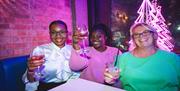 Party goers at Lucky Voice in Brighton raising a glass to the camera