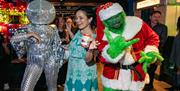 Party goers at Lucky Voice in Brighton dressed up in fancy dress outfits including the Grinch and a dancer wearing disco ball headwear.