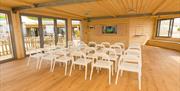 Inside shot of the Yellowave Beach House, a panelled room with views of the sea, with seating laid out theatre style.