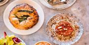 A table is full of delicious Burnt Orange dishes.