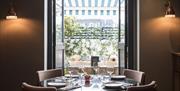 A table set next to an open window.