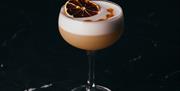 Cocktail with a slice of orange on the top.