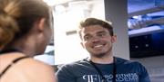 A pro fitness academy trainer speaking to a gym user.