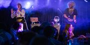 Image courtesy of dfphotography. Image from the show 2024 Blingo, performers on stage with wigs and a disco ball.