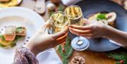 Celebrating the festive season at The Mercure Brighton Seafront, two glasses of Champagne in a cheers.