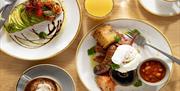 A table with hot drinks and a stunning looking cooked breakfast at One Kitchen