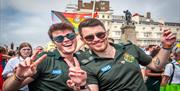 Image courtesy of Jim Carey. Two NHS workers pose for the camera with Pride flags in the background