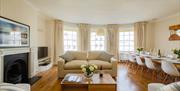 Comfy sofas and large dining table with chairs await guests.