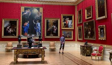 Man looking at painting in an opulent room