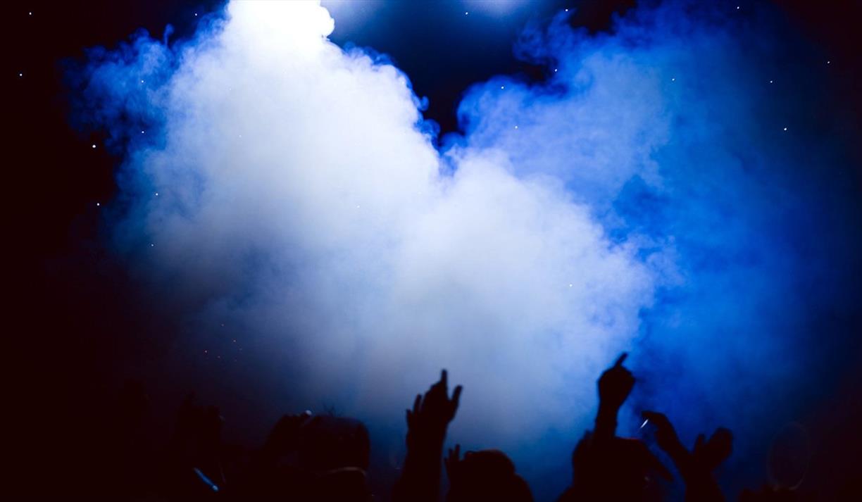 People with arms in the air in a club People with arms in the air in a club