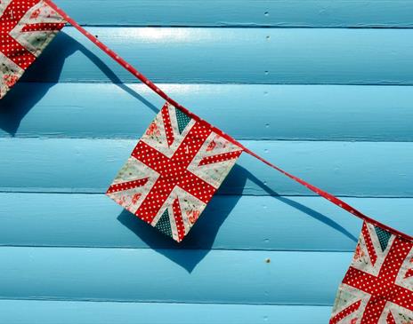 Bunting of the UKs flag against a light blue wall