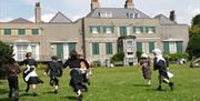 Children in historic dress running on lawn
