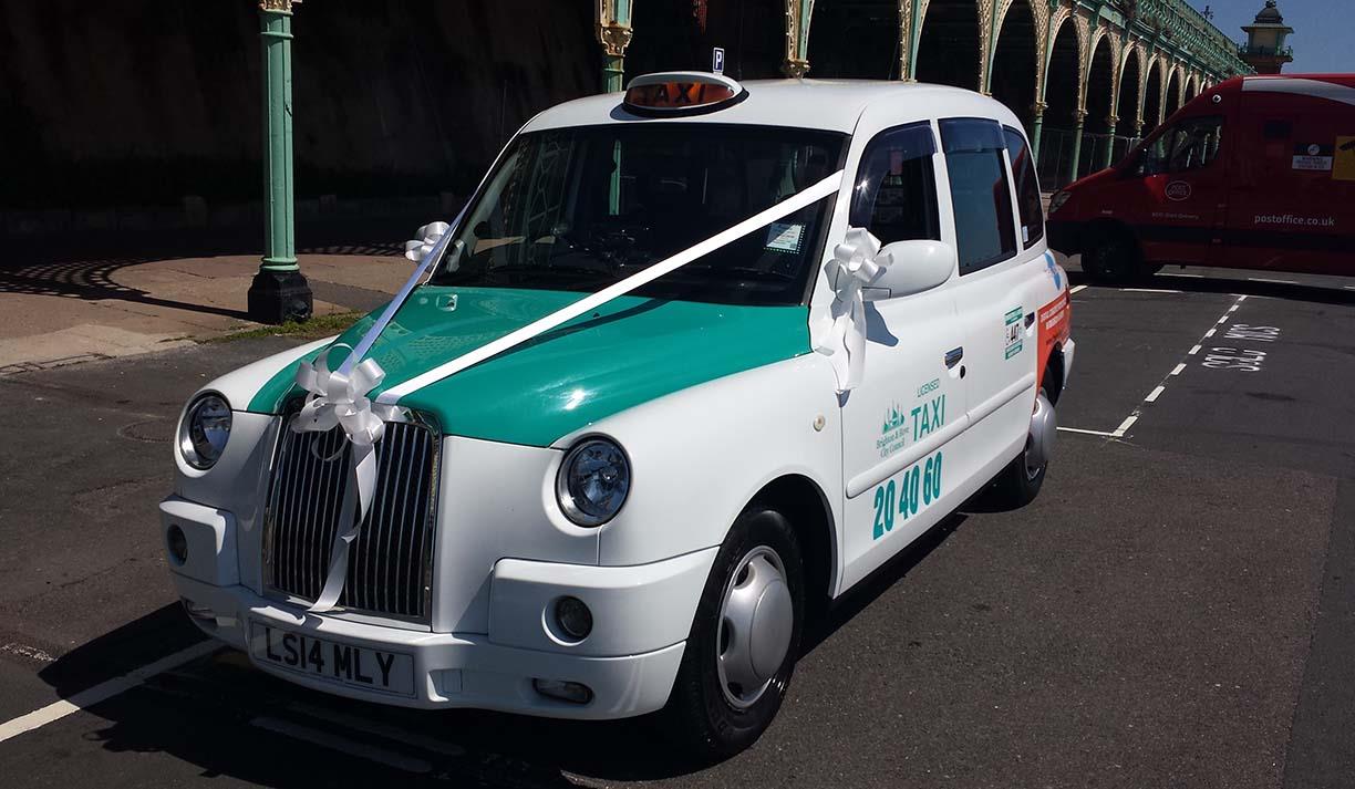 Brighton & Hove Radio Cabs vehicle parked on Madeira Drive decorated for collecting a wedding party. Brighton & Hove Radio Cabs vehicle parked on Madeira Drive decorated for collecting a wedding party.